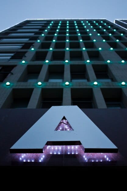 A modern office building with logos of well-known tech companies emblazoned on the facade, overshadowed by a large regulatory document, illustrating the potential impact of stricter regulations.