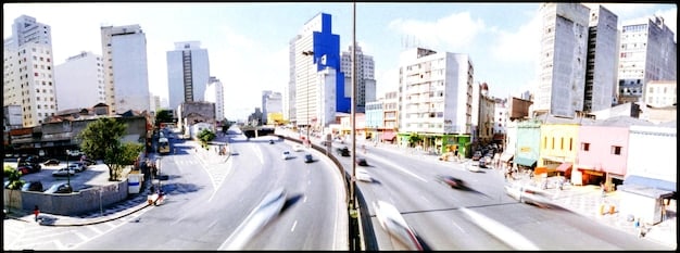 A split image showing two contrasting scenes: on one side, a bustling highway with numerous gas-powered vehicles emitting exhaust; on the other side, a serene landscape with electric vehicles charging at a solar-powered station, symbolizing the transition towards sustainable transportation.