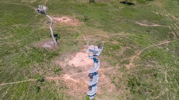 Drone photography portraying a vast network of interconnected pipelines extending across a rural landscape near a fracking site, interspersed with renewable energy installations like wind turbines and solar farms.