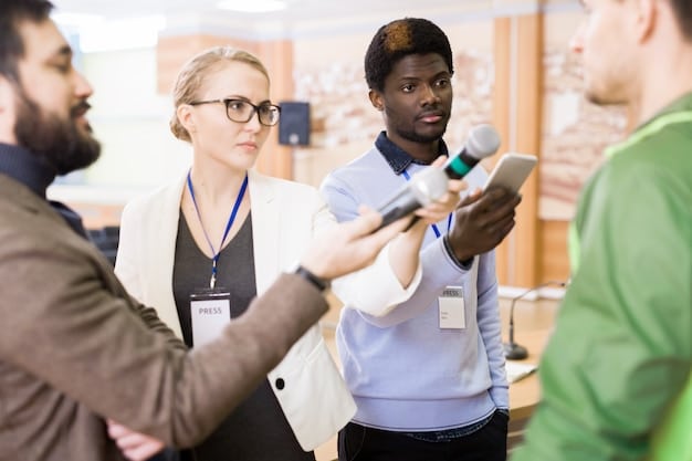 A diverse group of people attending a job fair, interacting with company representatives at various booths. The atmosphere is bustling, with prospective employees holding resumes and engaging in conversations. Banners and signs from different companies are visible in the background.