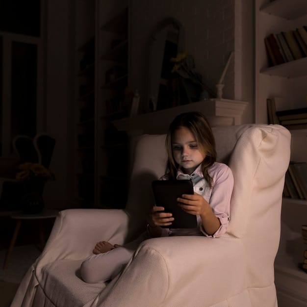 A child sitting on a couch, bathed in the light from a tablet screen, with various other devices scattered around.