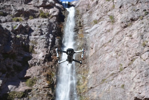 A detailed, close-up shot of an AI-powered drone flying over a rugged, mountainous terrain. The drone is equipped with advanced sensors and cameras. This image emphasizes the use of AI in surveillance and remote operations.